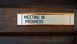 A sign reading 'meeting in progress'