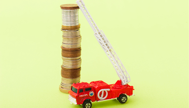 The ladder of a toy firetruck leans against a tall stack of coins