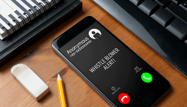 Smartphone on wooden table shows a whistleblower alert from an anonymous caller