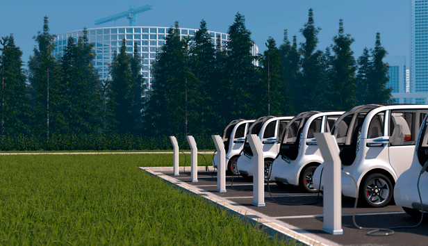 Shows a fleet of mid-sized electric vehicles being charged at a public charging station