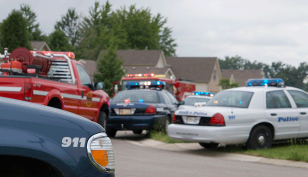 Several emergency vehicles are parked on a neighborhood street
