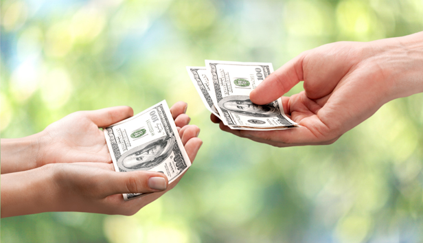 Close up of hand of one person giving money to another person