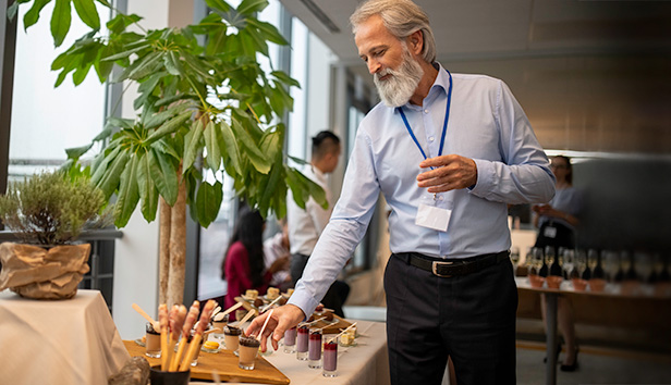A male conference attendee choosing dessert from a table