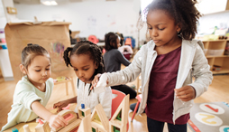 3 children building with wooden blocks