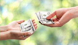 Close up of hand of one person giving money to another person