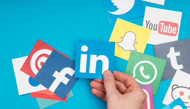 A hand chooses among several options of social media apps