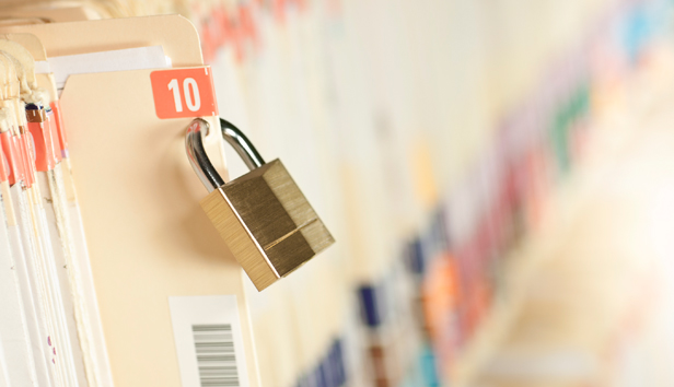 A bunch of file folders with a lock on one folder