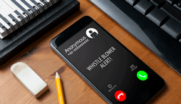 Smartphone on wooden table shows a whistleblower alert from an anonymous caller