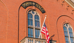 Exterior of a town hall with flag displayed